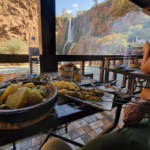 Riverside terrace restaurant at Ouzoud Waterfalls Morocco — traditional Moroccan lunch with waterfall view on Marrakech day trip