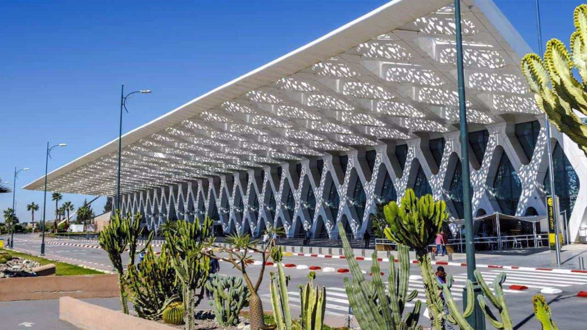 Marrakech Menara Airport exterior entrance with palm trees and clear blue sky