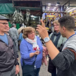 Certified local guide leading private food tour group through Marrakech souks medina — authentic evening experience Morocco